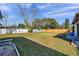 Large, grassy backyard with a privacy fence and mature trees in a residential area at 1016 Mandalay Dr, Brandon, FL 33511