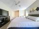 Bright bedroom featuring a ceiling fan, TV, and a large comfortable bed at 10525 Mira Vista Dr, Port Richey, FL 34668