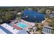 Aerial view of a beautiful community pool, lake, and recreation area with shuffleboard courts at 10525 Mira Vista Dr, Port Richey, FL 34668