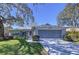 Charming single-story home featuring a spacious screened garage, lush lawn, and well-maintained landscaping at 10525 Mira Vista Dr, Port Richey, FL 34668