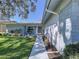 Inviting single-story home with a well-manicured lawn, colorful flower beds, and a cozy seating area by the front door at 10525 Mira Vista Dr, Port Richey, FL 34668