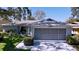 Charming single-story home featuring a spacious screened garage, lush lawn, and well-maintained landscaping at 10525 Mira Vista Dr, Port Richey, FL 34668