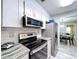 This updated kitchen boasts granite counters, stainless appliances, and a clear view to the adjacent dining room at 10525 Mira Vista Dr, Port Richey, FL 34668