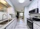 Bright kitchen boasts white cabinets, granite countertops, stainless steel appliances, and an open view to the living area at 10525 Mira Vista Dr, Port Richey, FL 34668
