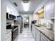 This well-lit kitchen offers stainless steel appliances, granite countertops, and a view to the dining room at 10525 Mira Vista Dr, Port Richey, FL 34668
