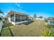 Exterior view of the home highlighting the backyard, screened-in patio, and canal at 13614 Evelane Dr, Hudson, FL 34667