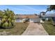 A well-maintained single-story home with a two-car garage, manicured lawn, and mature landscaping provides great curb appeal at 13614 Evelane Dr, Hudson, FL 34667
