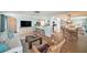 Open living space with coastal decor, large TV, breakfast bar and dining area with tile floors and ample seating at 13614 Evelane Dr, Hudson, FL 34667