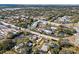 Aerial shot shows condos nestled among lush greenery, serene pond, and neighborhood streets at 2085 Hunters Glen Dr # 228, Dunedin, FL 34698