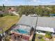 Aerial view of the fenced in back yard, screened-in pool, patio and lush greenery at 2509 Estancia Blvd, Clearwater, FL 33761