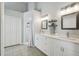 Bright bathroom featuring double vanity with white cabinets, framed mirrors and a walk-in shower at 2509 Estancia Blvd, Clearwater, FL 33761