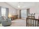 Cozy Bedroom featuring soft pink walls, a crib, changing table, and comfortable seating at 2509 Estancia Blvd, Clearwater, FL 33761
