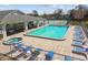 Aerial view of a community pool with lounge chairs, tables and tennis court at 2509 Estancia Blvd, Clearwater, FL 33761