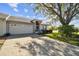 Attractive one-story home boasts a spacious driveway, two car garage, and mature tree in the front yard at 2509 Estancia Blvd, Clearwater, FL 33761