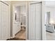 Hallway view to the bathroom with white cabinets, a toilet, and a view of the living room at 2509 Estancia Blvd, Clearwater, FL 33761
