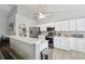 Bright kitchen with white cabinets, stainless appliances, tile floor, and breakfast bar at 2509 Estancia Blvd, Clearwater, FL 33761