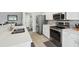 Open kitchen with white quartz counters, stainless appliances, and breakfast bar at 2509 Estancia Blvd, Clearwater, FL 33761