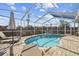 Inviting screened-in pool with a brick paver deck, lounge chairs and umbrella at 2509 Estancia Blvd, Clearwater, FL 33761