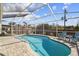 Inviting screened-in pool with a brick paver deck and two Adirondack chairs at 2509 Estancia Blvd, Clearwater, FL 33761