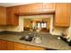 Charming kitchen featuring wood cabinets, granite countertops, and a convenient pass-through to the living area at 2689 Sabal Springs Cir # 103, Clearwater, FL 33761