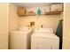 Convenient laundry room includes a washing machine, dryer, and shelving at 2689 Sabal Springs Cir # 103, Clearwater, FL 33761