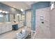 Modern bathroom with double vanities, a large glass shower with rainfall shower head, and marble floors at 29924 Rusco Ct, Wesley Chapel, FL 33545