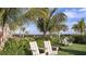 Community common area featuring Adirondack chairs, palm trees, manicured lawn, and well-maintained landscaping at 29924 Rusco Ct, Wesley Chapel, FL 33545