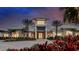 Exterior view of community clubhouse with modern architecture and lush landscaping at dusk at 29924 Rusco Ct, Wesley Chapel, FL 33545