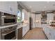 Well-equipped kitchen with stainless appliances, white cabinetry, and stone countertops at 29924 Rusco Ct, Wesley Chapel, FL 33545