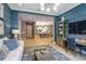 Open-concept living room with blue accent wall flows into dining area with modern chandelier at 29924 Rusco Ct, Wesley Chapel, FL 33545