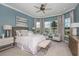 Spacious bedroom with large windows, sitting area, ceiling fan, and neutral decor at 29924 Rusco Ct, Wesley Chapel, FL 33545