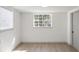 Bright, white bedroom with a large window and light wood-look flooring at 306 Midwood Dr, Plant City, FL 33566