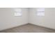 White bedroom with two windows and luxury vinyl plank flooring at 306 Midwood Dr, Plant City, FL 33566