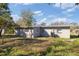 Rear exterior view of a single story home with a metal roof in a suburban landscape at 306 Midwood Dr, Plant City, FL 33566