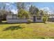 Quaint single-story home with a well-maintained lawn and mature trees at 306 Midwood Dr, Plant City, FL 33566