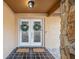 Inviting double front doors adorned with wreaths, set against a stone accent wall and decorative tile flooring at 3092 Osprey Ln, Clearwater, FL 33762