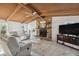Comfortable living room with a stone fireplace and wood-beamed ceilings, perfect for relaxing and entertaining at 3092 Osprey Ln, Clearwater, FL 33762