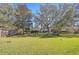 Lush backyard featuring mature trees, green grass, and a wooden fence for privacy at 3133 Beaver Pond Trl, Valrico, FL 33596