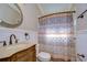 Charming bathroom with ornate vanity, bronze fixtures, and patterned shower curtain at 3133 Beaver Pond Trl, Valrico, FL 33596