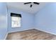 Cozy bedroom with wood-look flooring, neutral paint, and a large window at 3133 Beaver Pond Trl, Valrico, FL 33596