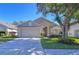 Charming single-story home with a well-manicured lawn, mature trees, and an attached two-car garage at 3133 Beaver Pond Trl, Valrico, FL 33596