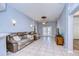 Spacious living room with tile flooring, comfortable seating, and decorative ceiling fan at 3133 Beaver Pond Trl, Valrico, FL 33596