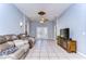 Living room featuring tile floors, comfortable seating, and a decorative ceiling fan at 3133 Beaver Pond Trl, Valrico, FL 33596