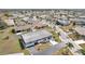 A high aerial shows a single-story home with an attached garage and a mature lawn in a quiet neighborhood at 334 Club Manor Dr, Sun City Center, FL 33573