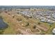 Scenic aerial view of a residential community with a winding golf course and lush green fairways and manicured bunkers at 334 Club Manor Dr, Sun City Center, FL 33573