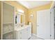 Bathroom with white vanity, tile floors, and bright lighting fixtures at 334 Club Manor Dr, Sun City Center, FL 33573