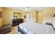 Comfortable bedroom with light wood floors, a ceiling fan, and a dresser with a large mirror at 334 Club Manor Dr, Sun City Center, FL 33573