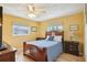 Bright bedroom featuring yellow walls, hardwood floors, ceiling fan, and a comfortable-looking bed at 334 Club Manor Dr, Sun City Center, FL 33573