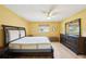 Bedroom featuring wood floors, a ceiling fan, dresser with mirror, and bright natural light at 334 Club Manor Dr, Sun City Center, FL 33573