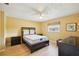 Bright bedroom with yellow walls, hardwood floors, ceiling fan, and a comfortable-looking bed at 334 Club Manor Dr, Sun City Center, FL 33573